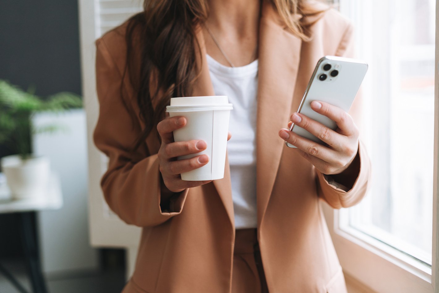 Crop photo of business woman in beige suit with paper cup